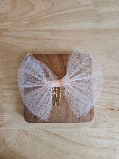 Light Orange tulle bow with a gold cross on a wooden box against a wooden background