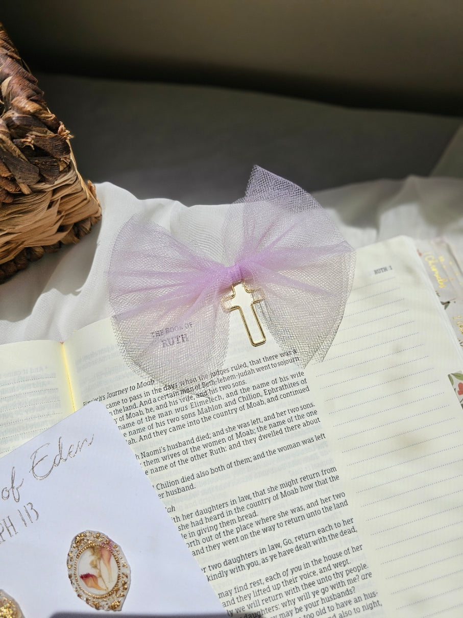 Purple Tulle bookmark bow including a cross on an open book with a plant beside it and other stationery.