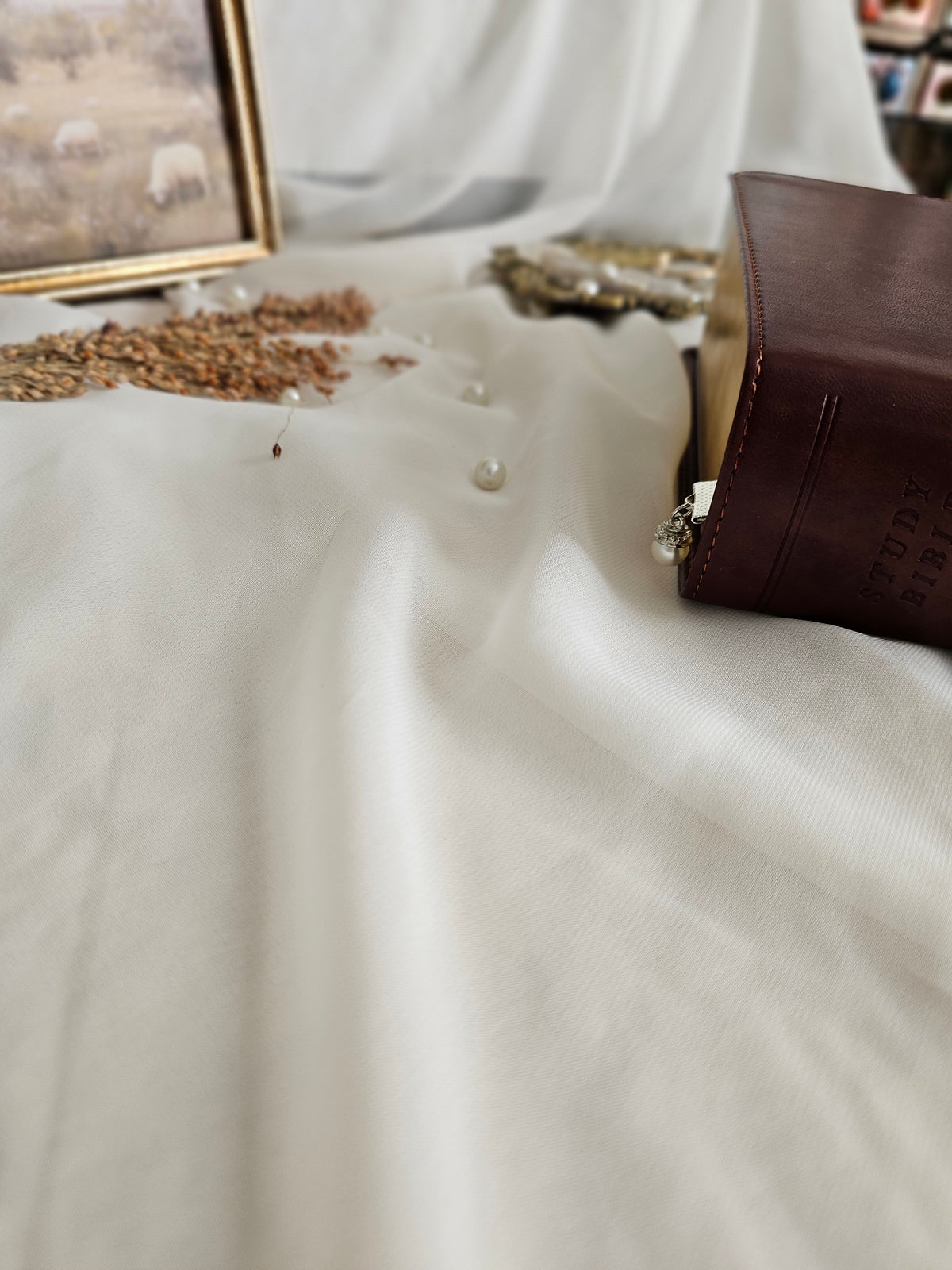 Pearl charm sticking out of Bible. 